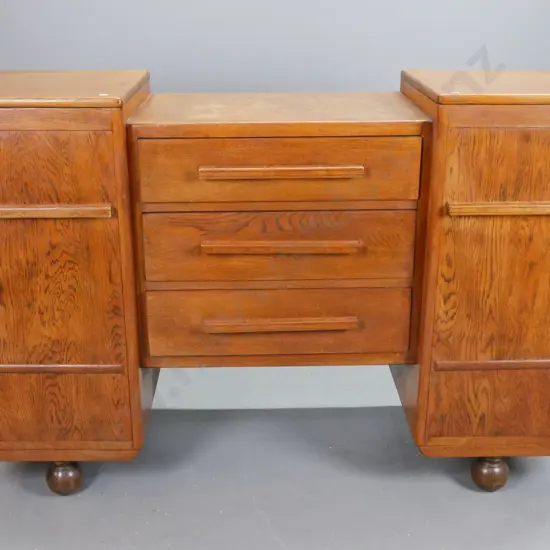 art deco oak sideboard with stepped top, 2 cupboard doors flanking 3 long drawers. Top drawer