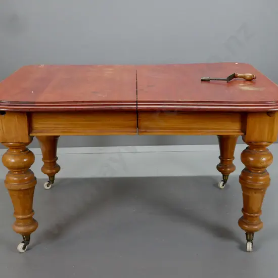 New Zealand colonial rimu turned leg wind out table, on white china cup casters. Has borer in the top