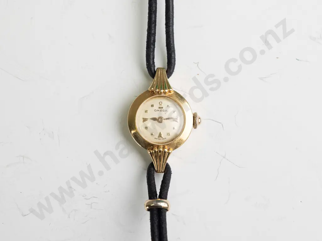 ladies Omega watch,18ct (approx 5gms) case with cordette strap,plated fillings. Watch is in going order Image 1++