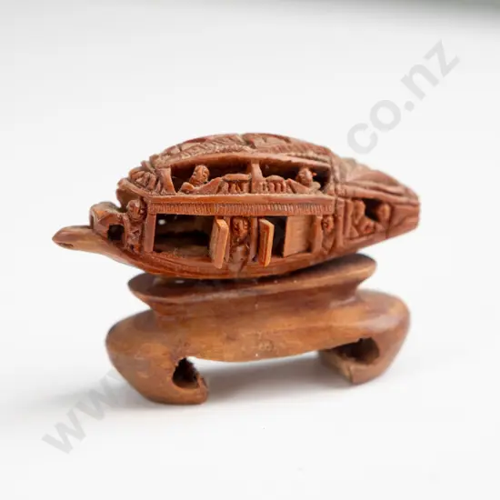 Chinese intricately carved fruit stone or pit, carved into boat shape with movable doors, mounted on wooden stand. Seems