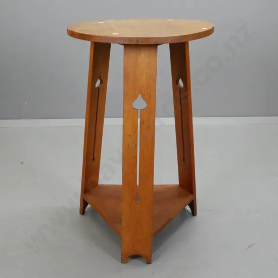 art nouveau oak side table with circular top and pierced arrow sides. H770 Diam450