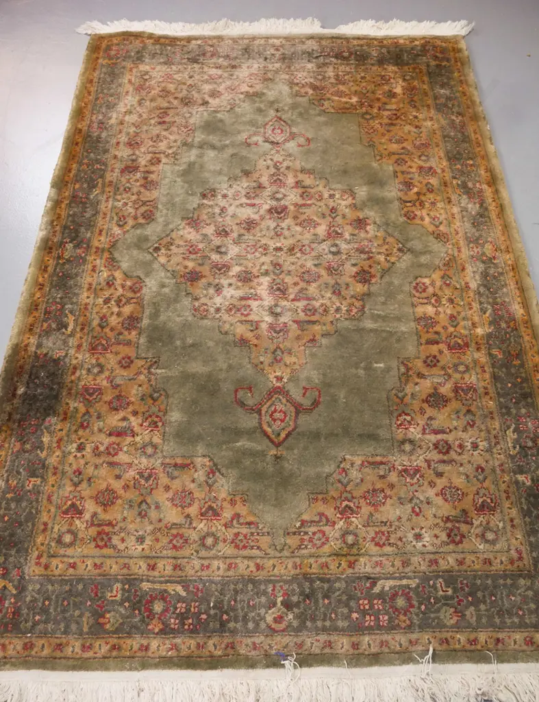 Persian-style floor rug, green ground w/ red & camel geometric & floral borders. Some wear & discolouration. W-1920 Image 1++
