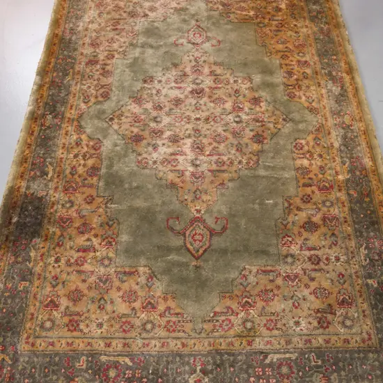 Persian-style floor rug, green ground w/ red & camel geometric & floral borders. Some wear & discolouration. W-1920