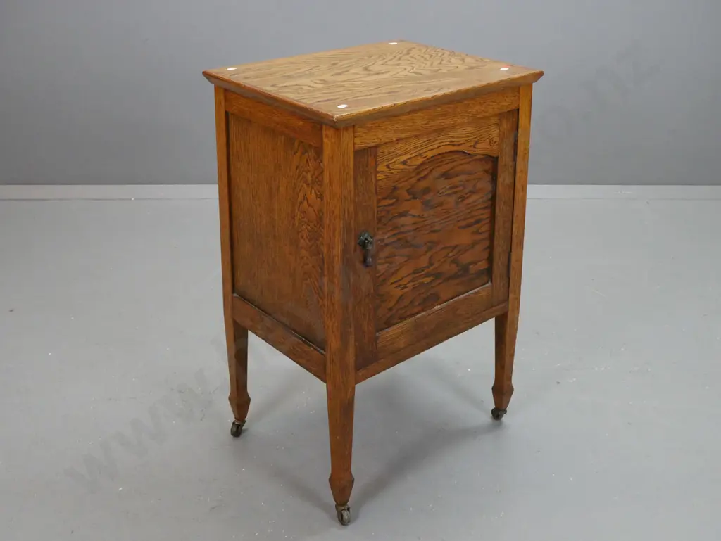 vintage oak bedside cabinet with panelled sides and door with drop handle, square legs on spade feet & metal casters - Image 1++