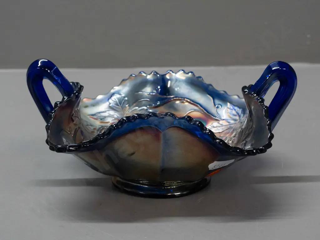 small cobalt blue carnival glass bowl - handled leaf shape, with grape leaf motifs H-80 W-180 across handles Image 1++