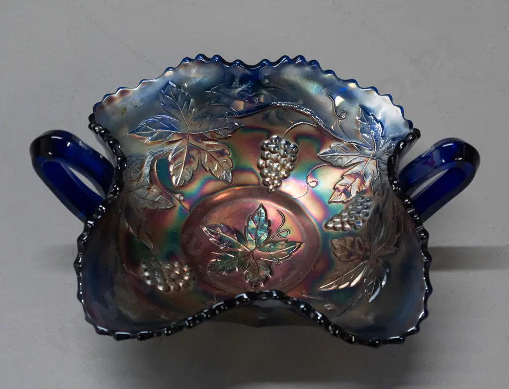 small cobalt blue carnival glass bowl - handled leaf shape, with grape leaf motifs H-80 W-180 across handles Image 1++