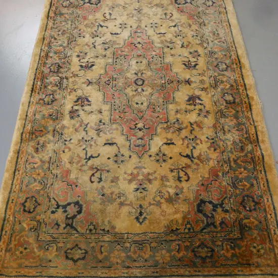 floor rug w/ geometric border & central motif in blues pinks & camel tones. Some wear to fringe & edging, some staining.