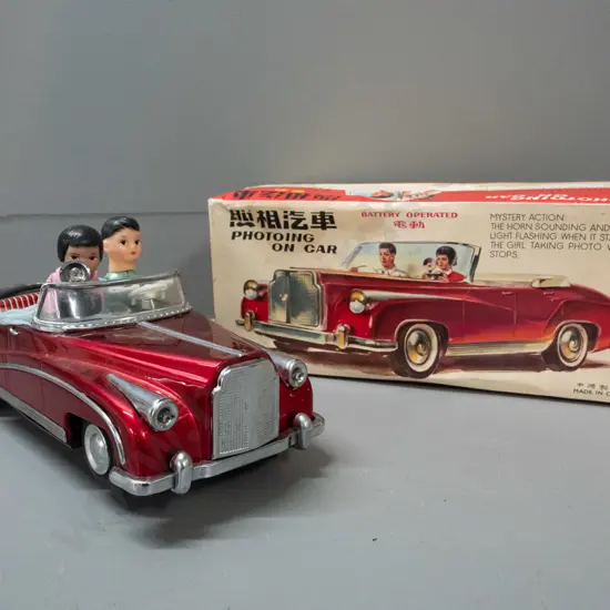 retro battery powered Chinese tin toy vehicle with driver and passenger holding a camera - in original box. Untested,