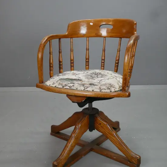 vintage oak swivel office chair with turned back supports, upholstered seat. 4 sweeping legs to X frame