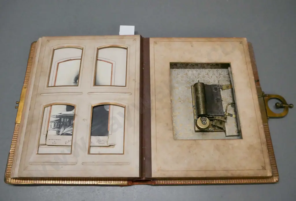 Leather-bound photo album w/ metal clasp, corners & crest. 13 pages of photographs, mechanical music box mechanism. Image 1++