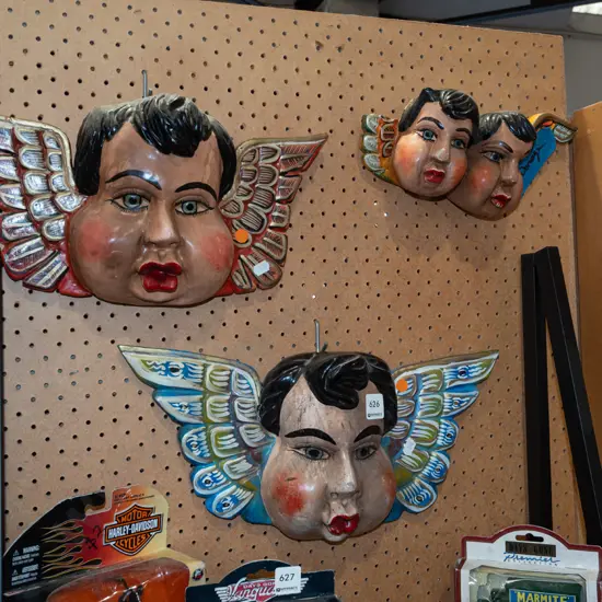 3x hand painted carved faces with wings - 1 has damage to 1 wing