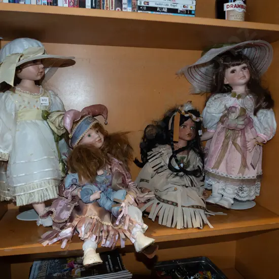shelf of 4x porcelain display dolls