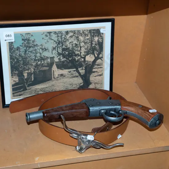 reproduction pistol, belt with long horn buckle, framed newspaper picture 
