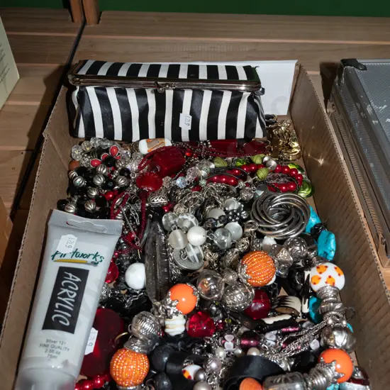 box; clutch purse, costume jewellery, tube of acrylic paint