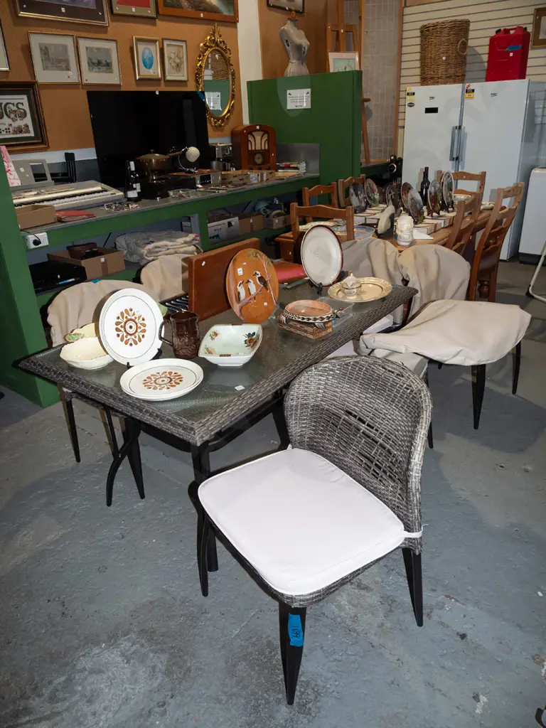 metal based woven plastic and glass top outdoor table with 6 matching woven plastic chairs Image 1++