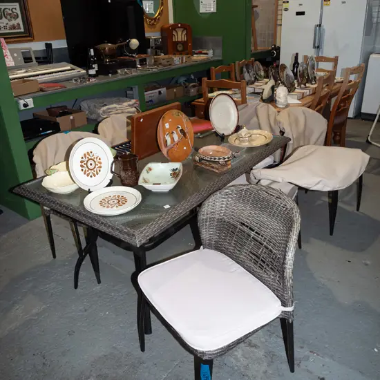metal based woven plastic and glass top outdoor table with 6 matching woven plastic chairs