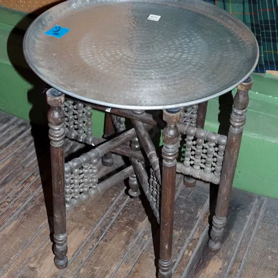 beaten alloy circular tray on turned wooden collapsable stand