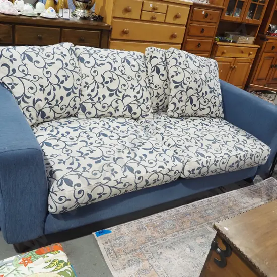 blue upholstered 3 seater settee with matching floral cushions