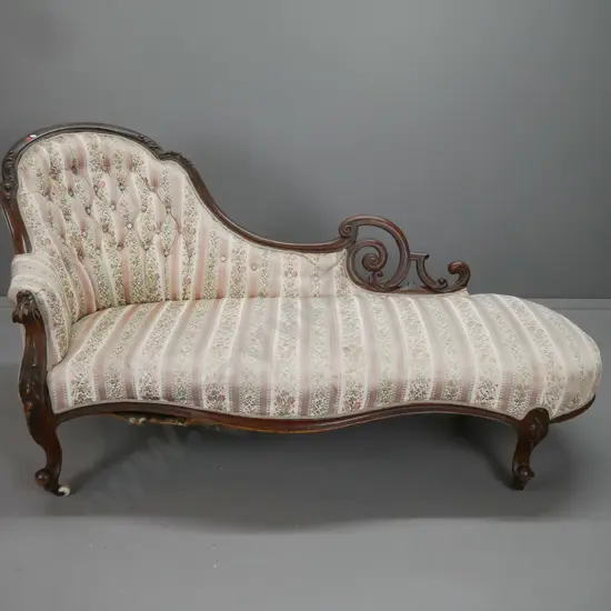 Victorian walnut chaise longue with shaped carved back, scrolling ends, serpentine front on carved cab legs, deep button