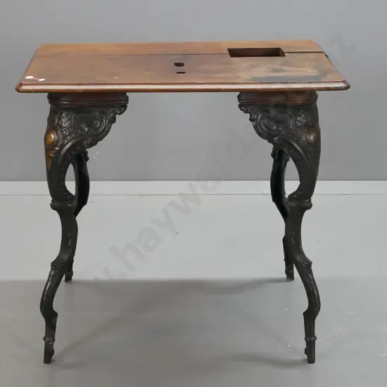 vintage work table with cast iron legs, oak top with cutouts and screw holes from removed apparatus - join in top is