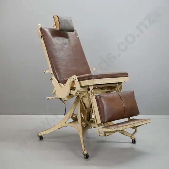 vintage dentist's/barber's chair with cast metal frame, 4-point base on large casters, elaborate adjustable spring and