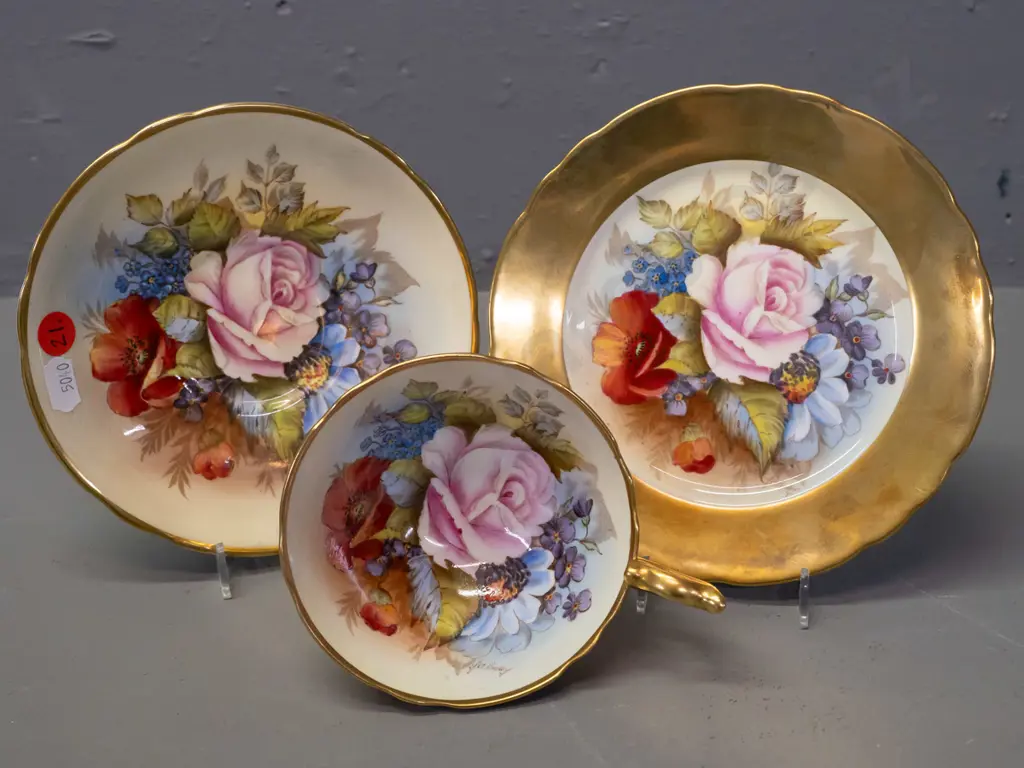 Aynsley hand painted floral and heavy gilt trio, each piece signed J. A. Bailey Image 1++