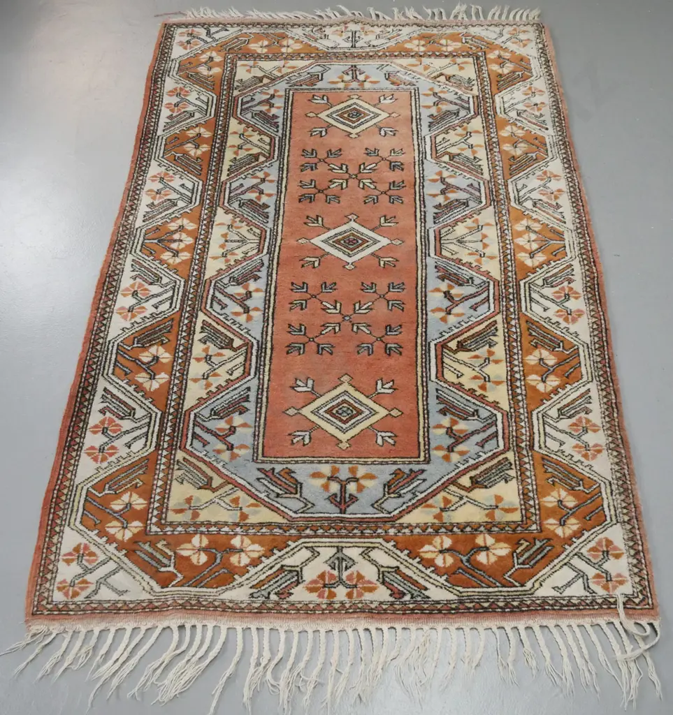 hand knotted geometric pattern wool floor rug with braided fringes - pale blues, pinks and browns - some wear Image 1++