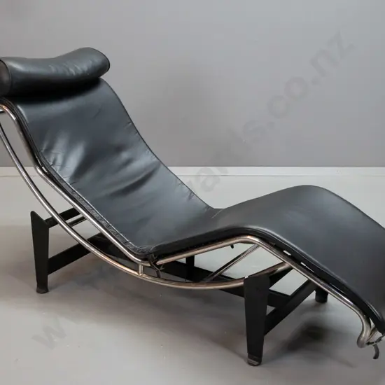 Corbusier LC4 style chrome and black leather reclining lounger on black steel stretcher base, nylon strapping under