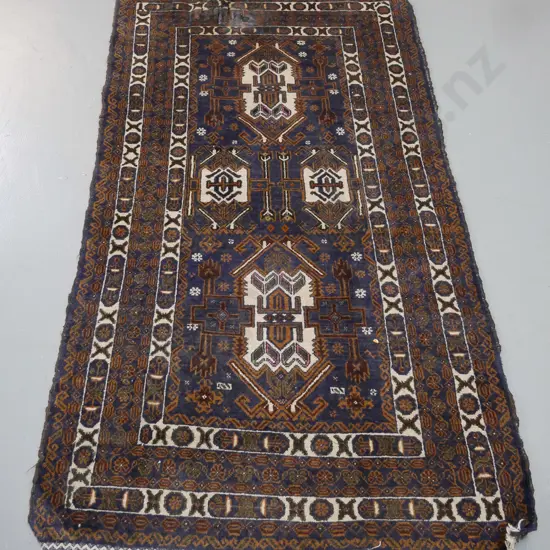 Persian style hand knotted wool floor rug - dark blue, ivory and brown - worn fringe and one small area torn or shredded