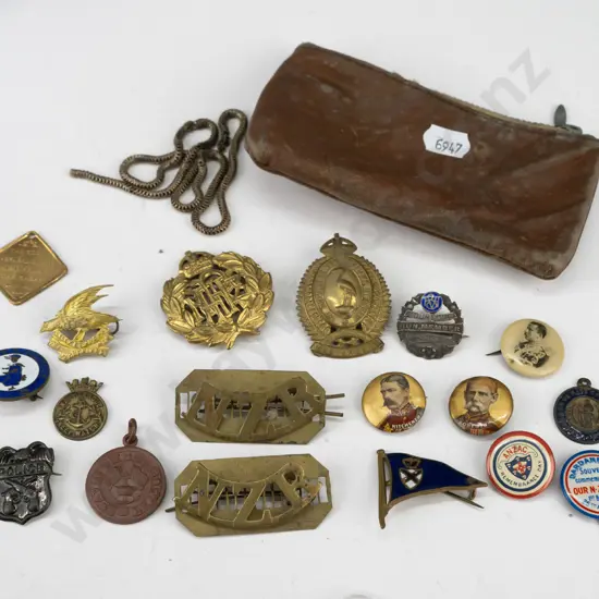 assorted New Zealand military, NZE and other hat and uniform badges, souvenir buttons, etc. with worn leather pouch incl
