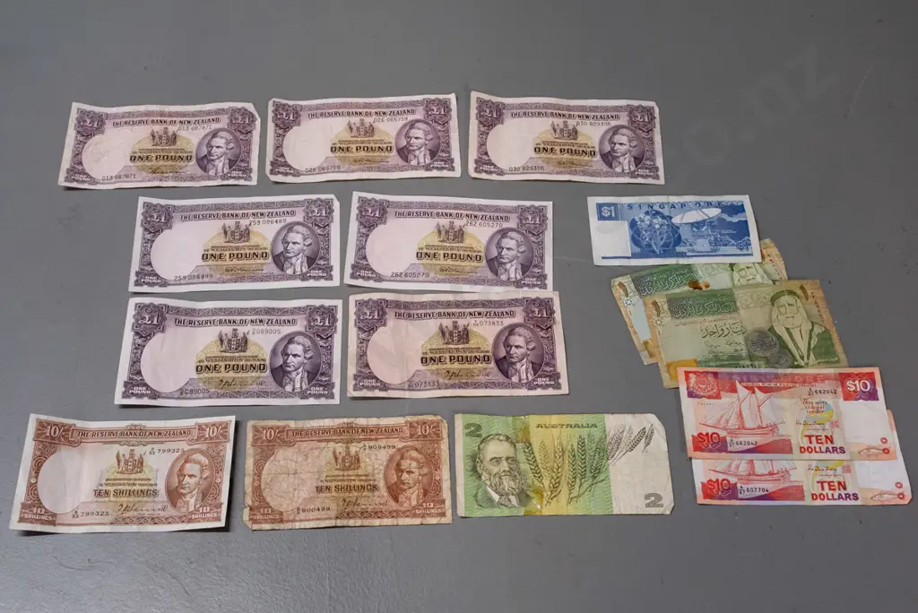 7 Reserve Bank of New Zealand 1 pound notes, 2 10-shilling notes, and some Singapore, Australia and other notes, varying Image 1++