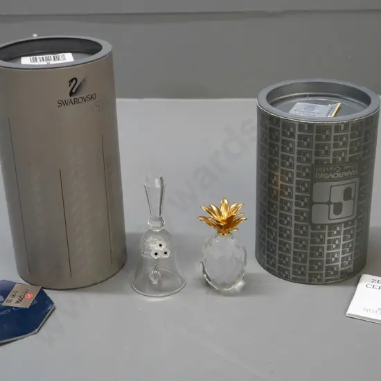 2 Swarovski crystal ornaments - bell with applied flowers and pineapple with gilded leaf top, both with original boxes.