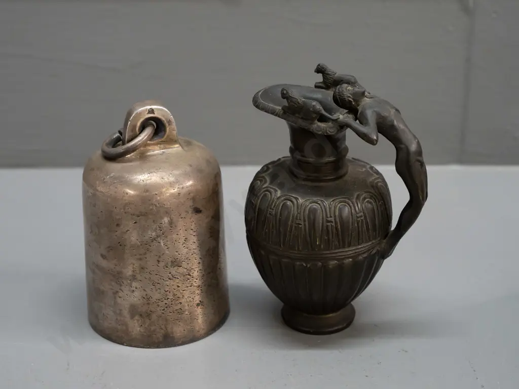 small cylindrical cast metal bell, no ringer, and a heavy cast brass urn jug with figural handle with bronze patina Image 1++