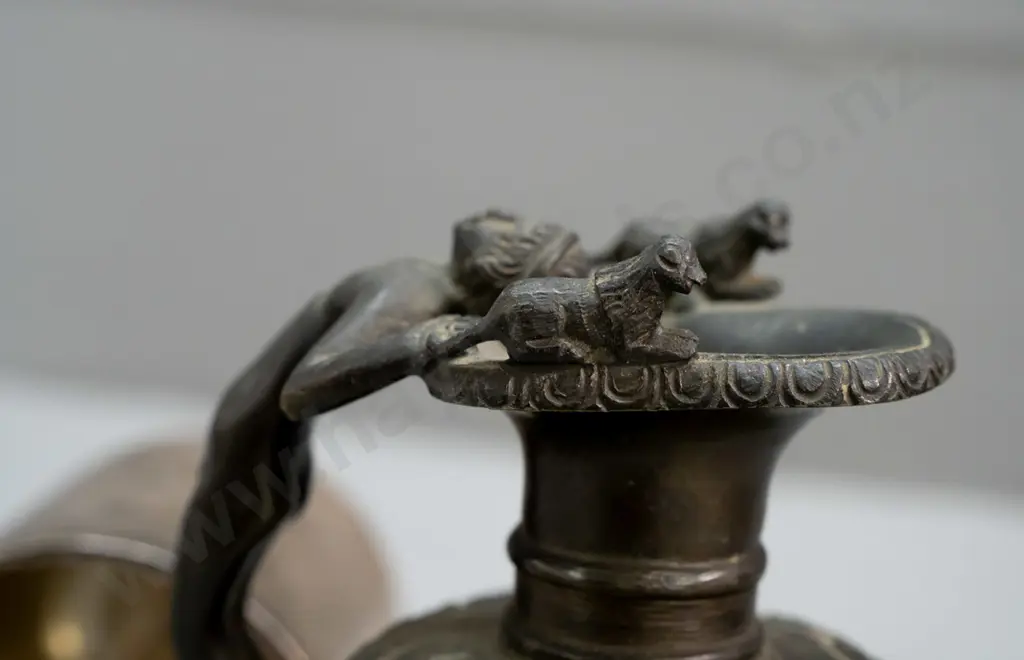 small cylindrical cast metal bell, no ringer, and a heavy cast brass urn jug with figural handle with bronze patina Image 1++
