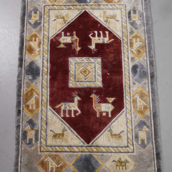 small wool floor rug with geometric animal motifs in red, blue, gold and beige L-940 W-610