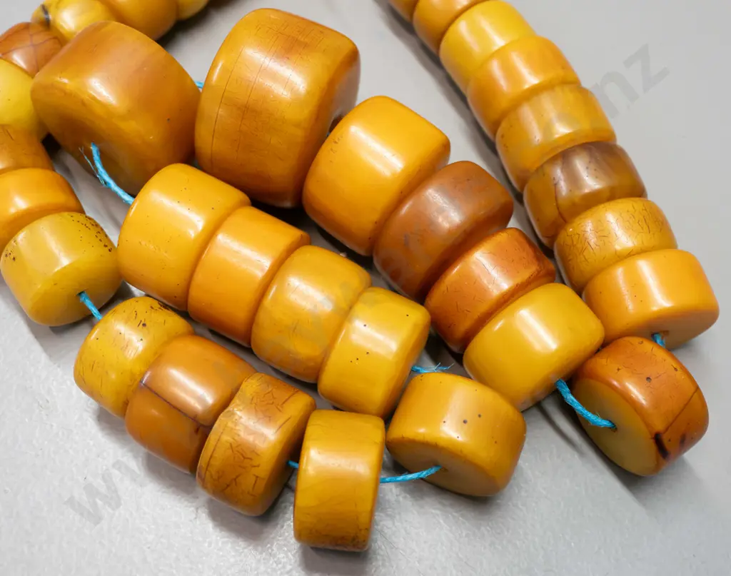 string of chunky disc shaped faux amber (bakelite?) beads - one larger bead is D-40 Image 1++