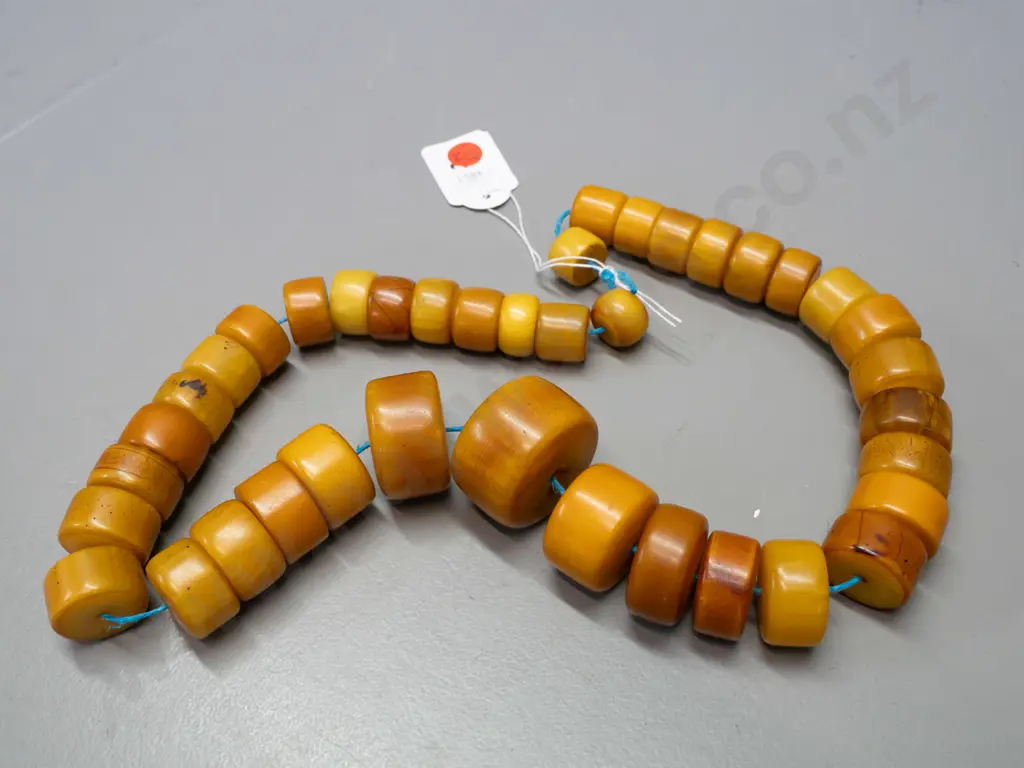 string of chunky disc shaped faux amber (bakelite?) beads - one larger bead is D-40 Image 1++