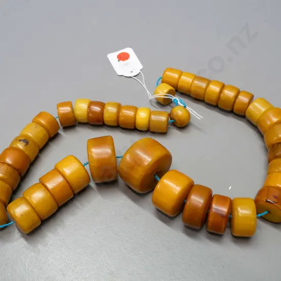 string of chunky disc shaped faux amber (bakelite?) beads - one larger bead is D-40