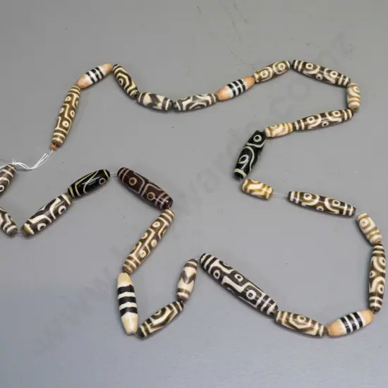 string of cylindrical mixed material (composite or glass?) possibly Tibetan beads L-500