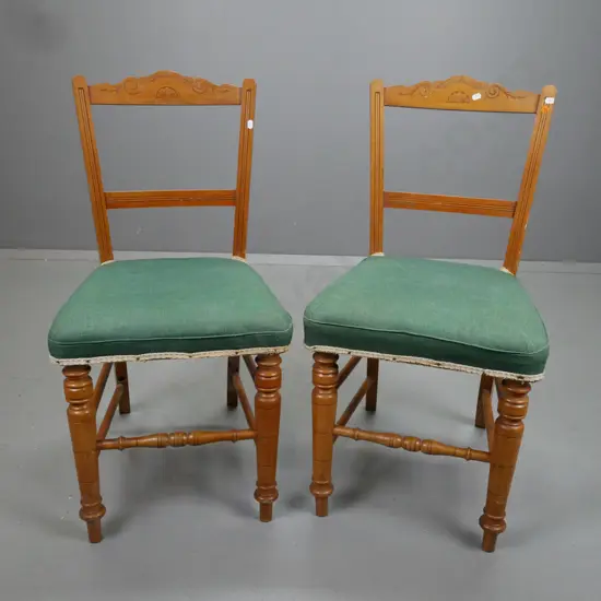 pair of Edwardian green upholstered rimu side chairs, carved back, turned legs and turned stretcher rails