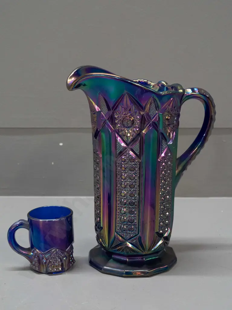 2 irridescent purple/blue carnival ware jugs - large one is H-210 W-180 handle to spout Image 1++