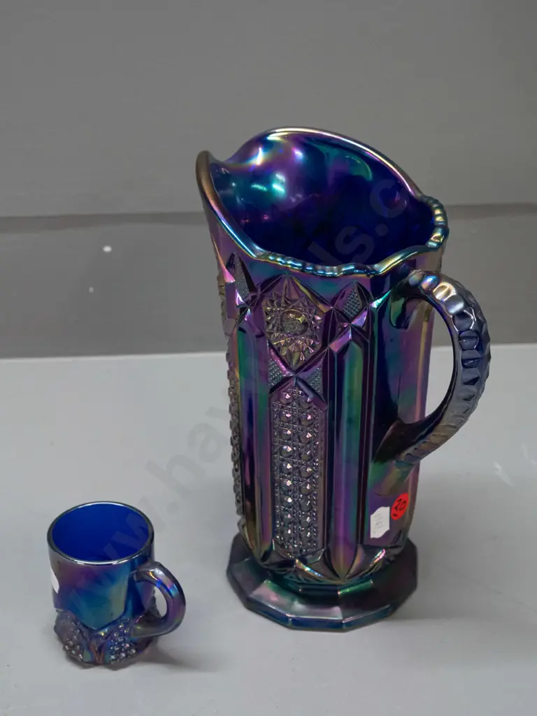 2 irridescent purple/blue carnival ware jugs - large one is H-210 W-180 handle to spout Image 1++