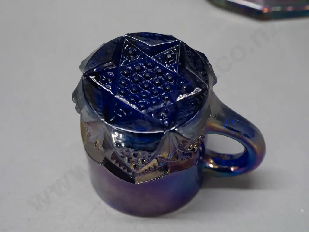 2 irridescent purple/blue carnival ware jugs - large one is H-210 W-180 handle to spout Image 1++