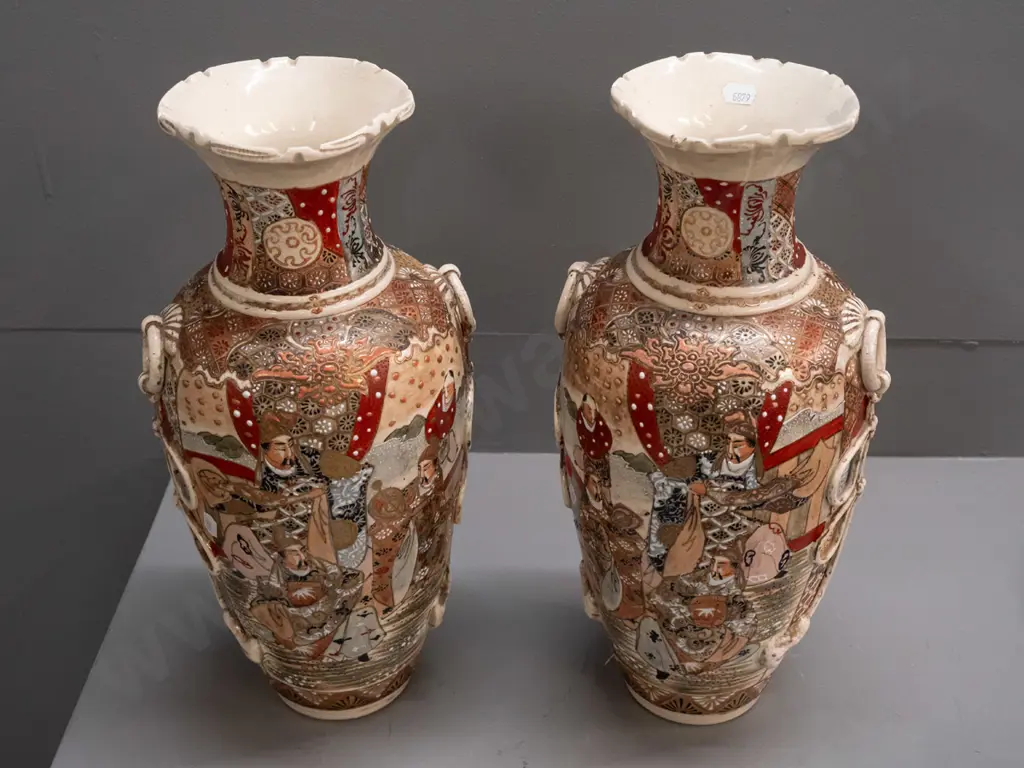 pair of Satsuma earthenware vases with frilled top, applied handles and panels of battle scene decoration, minor crack Image 1++