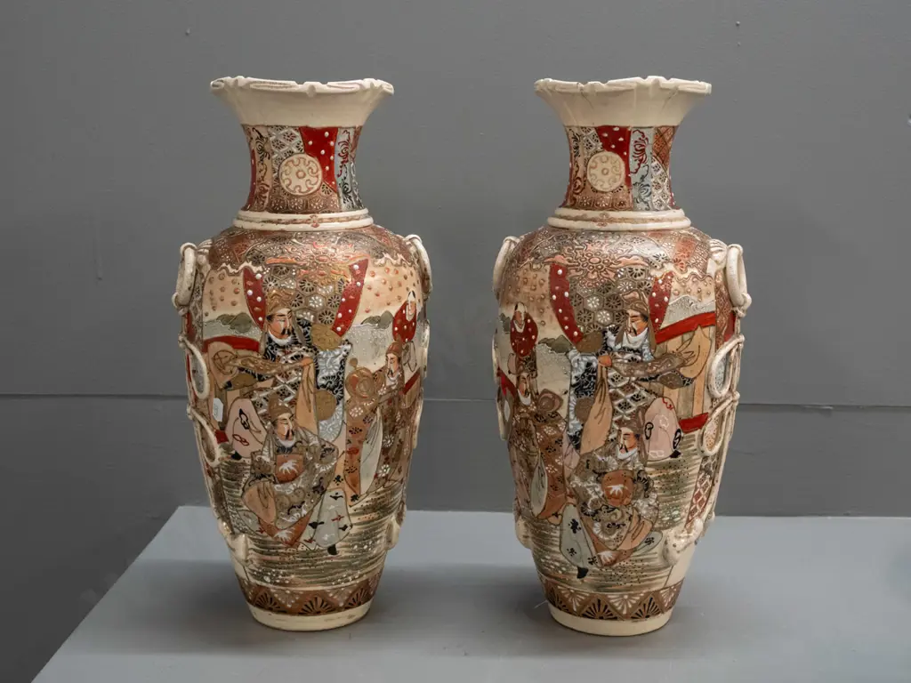 pair of Satsuma earthenware vases with frilled top, applied handles and panels of battle scene decoration, minor crack Image 1++