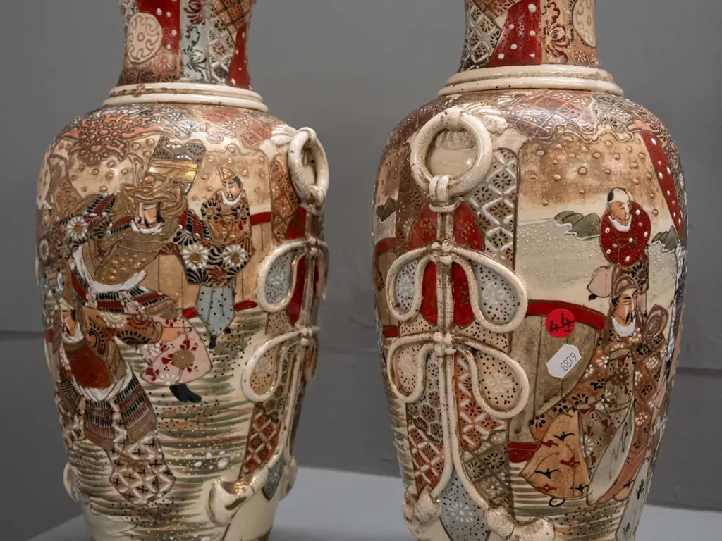pair of Satsuma earthenware vases with frilled top, applied handles and panels of battle scene decoration, minor crack Image 1++