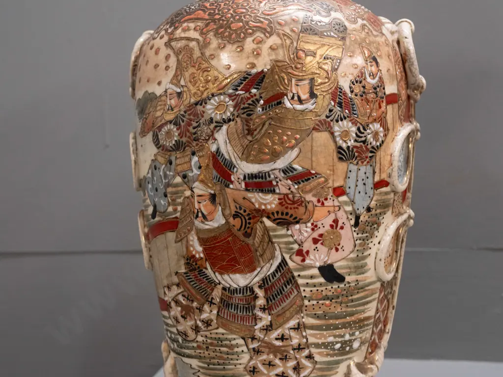pair of Satsuma earthenware vases with frilled top, applied handles and panels of battle scene decoration, minor crack Image 1++