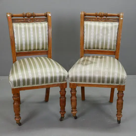 pair of colonial rimu & kauri Cromwellian style chairs with turned top rail and front legs, brown porcelain casters -
