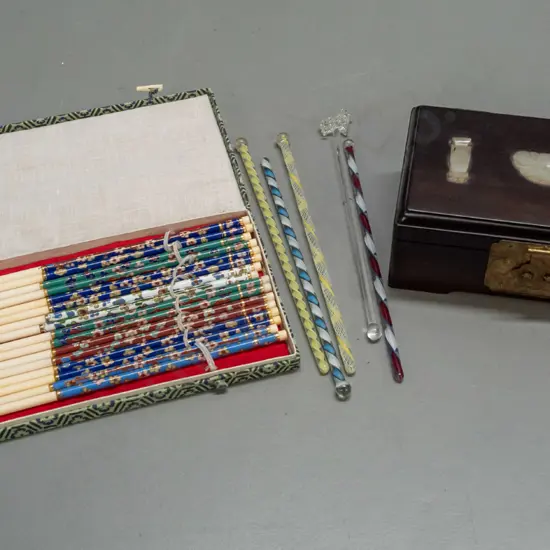 small lidded rosewood box with mother of pearl decorations, some twisted glass swizzle sticks, one with sheep, and cased