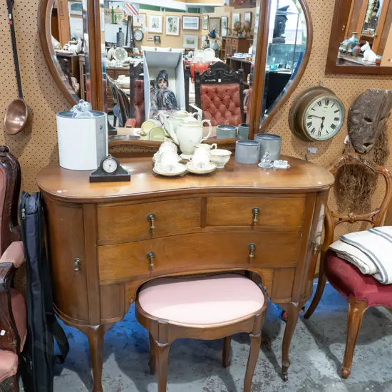 art deco mahogany kidney-shaped dressing table with bevelled edge shaped mirror back, brass drop handles to 2